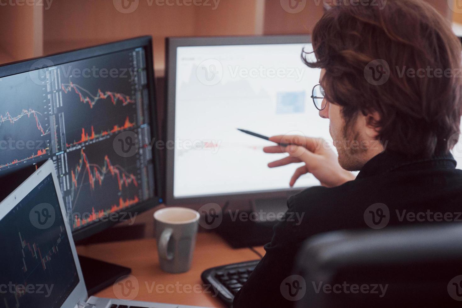 développer de nouvelles approches. vue arrière du jeune homme en tenue décontractée travaillant assis au bureau dans un bureau créatif photo