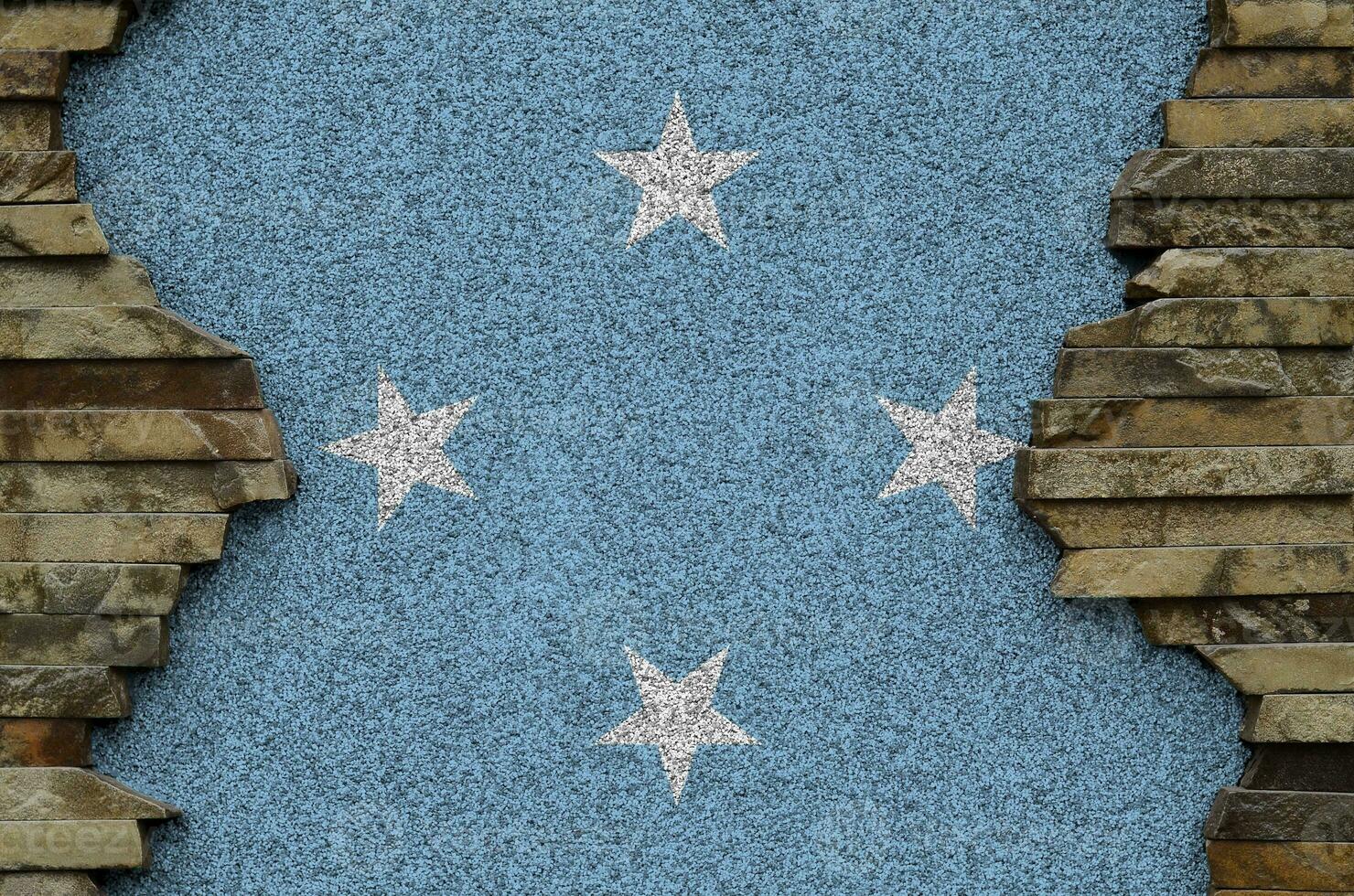 micronésie drapeau représenté dans peindre couleurs sur vieux pierre mur fermer. texturé bannière sur Roche mur Contexte photo