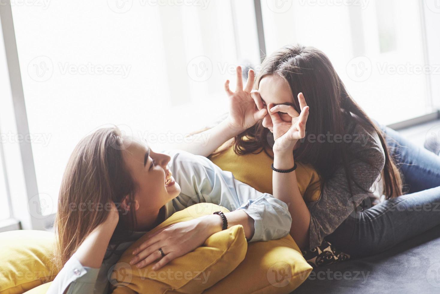 deux belles jeunes sœurs jumelles passent du temps avec des oreillers. frères et sœurs s'amusant à la maison concept photo