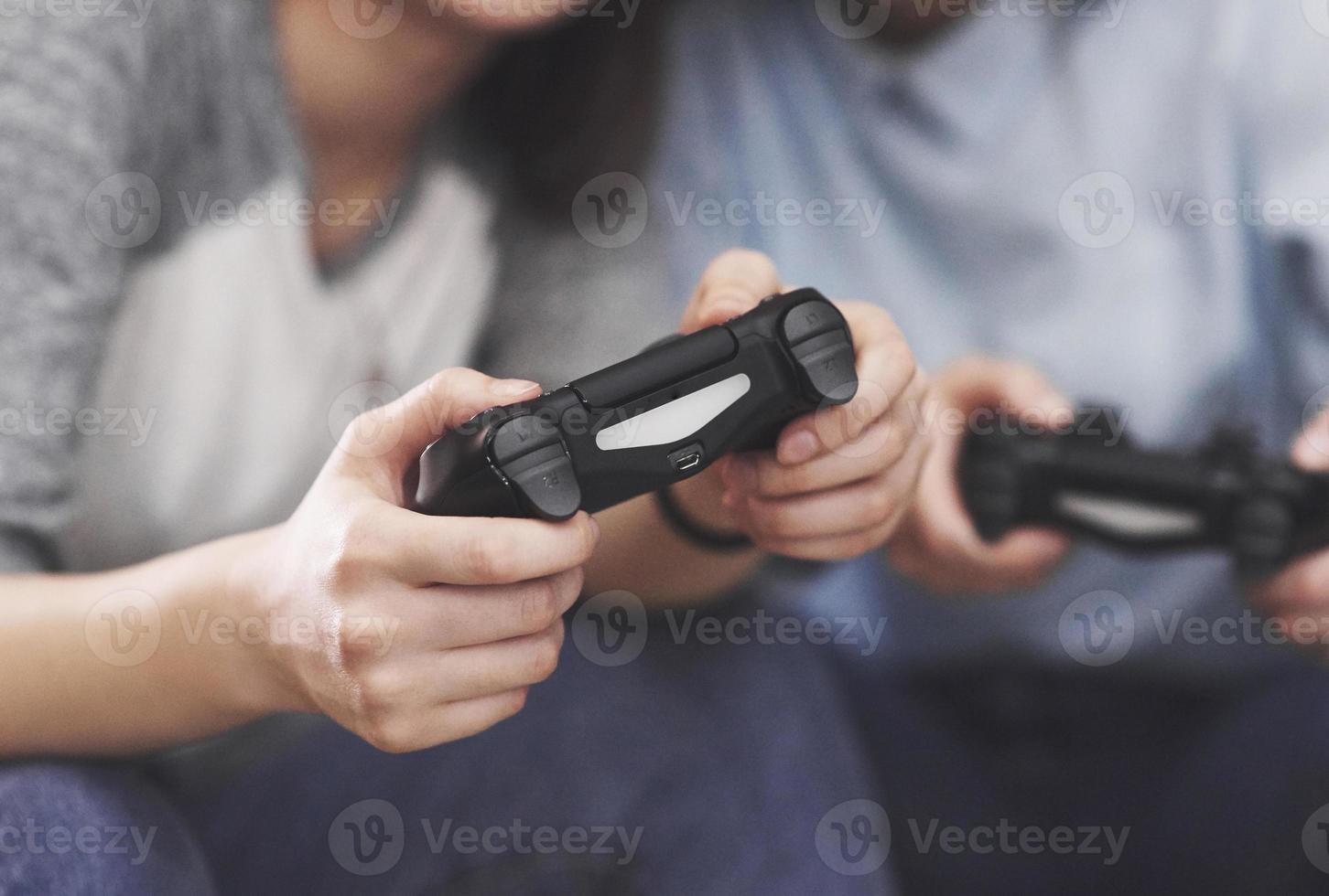 des soeurs jumelles jouent sur la console. les filles tiennent des joysticks dans leurs mains et s'amusent photo