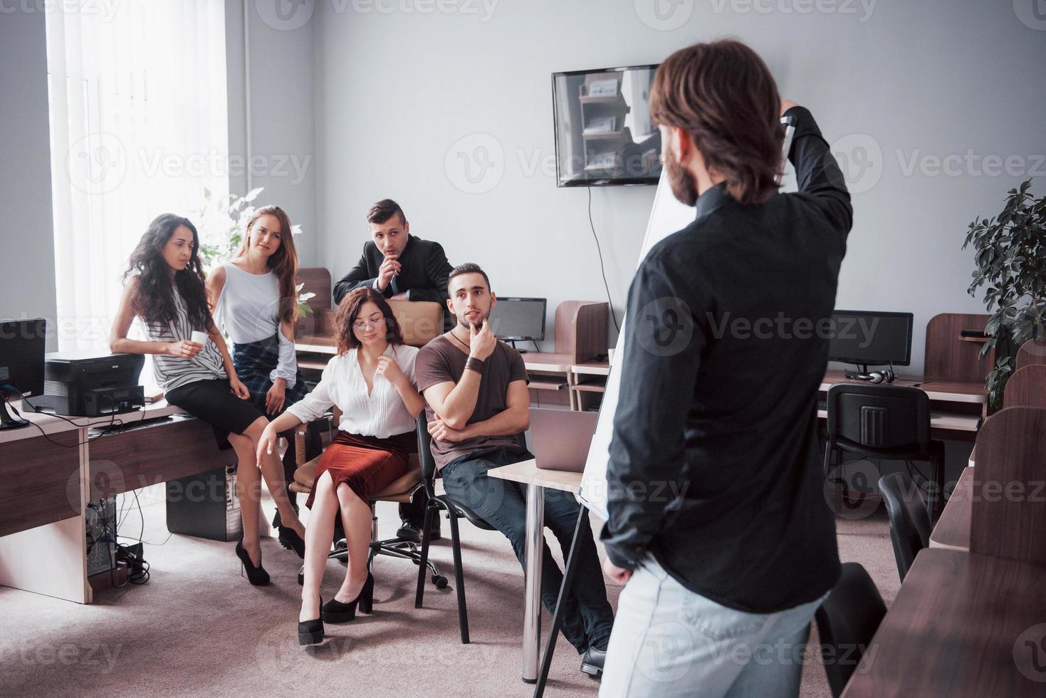 portrait d'une joyeuse équipe créative de personnes parlant au bureau lors de la réunion. photo