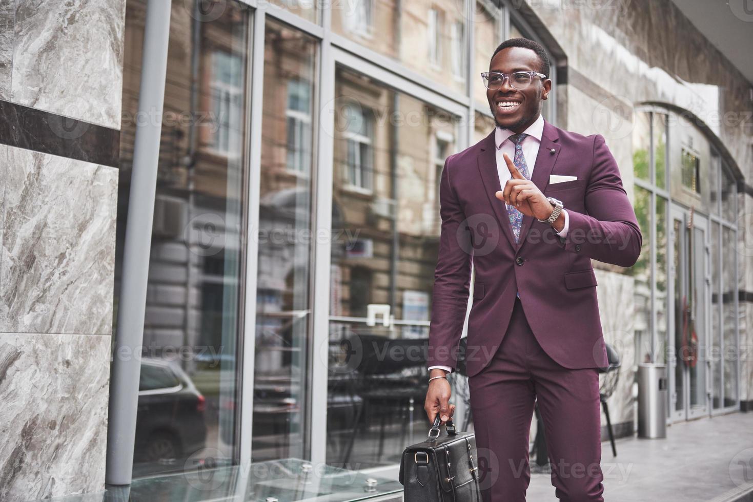 portrait d'un jeune homme d'affaires afro-américain magnifique avec une mallette. réunion d'affaires. photo