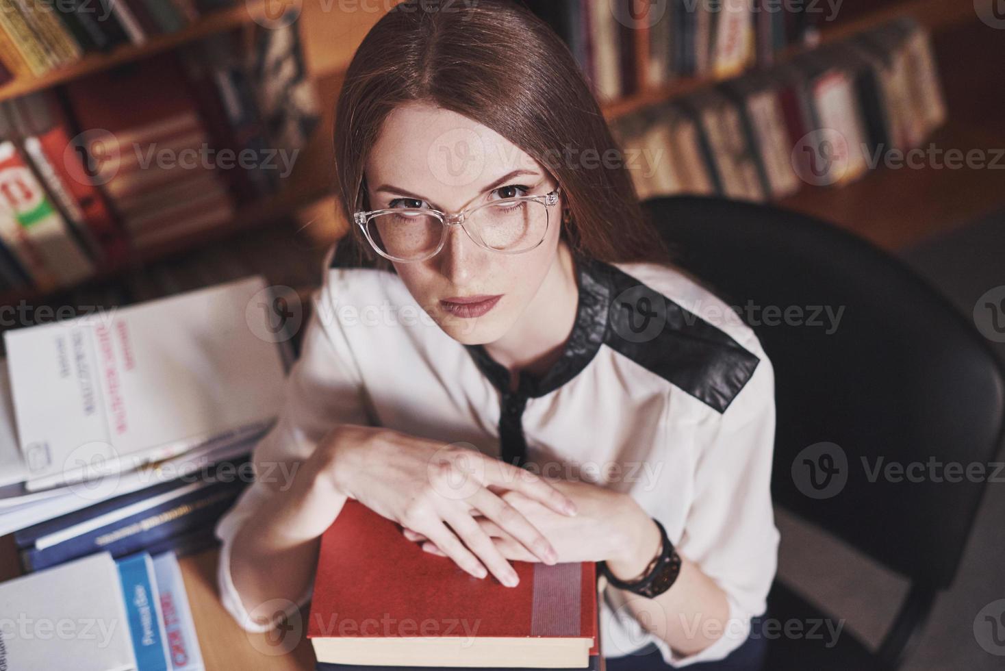 une jeune étudiante est fatiguée dans la salle de lecture de l'ancienne bibliothèque photo