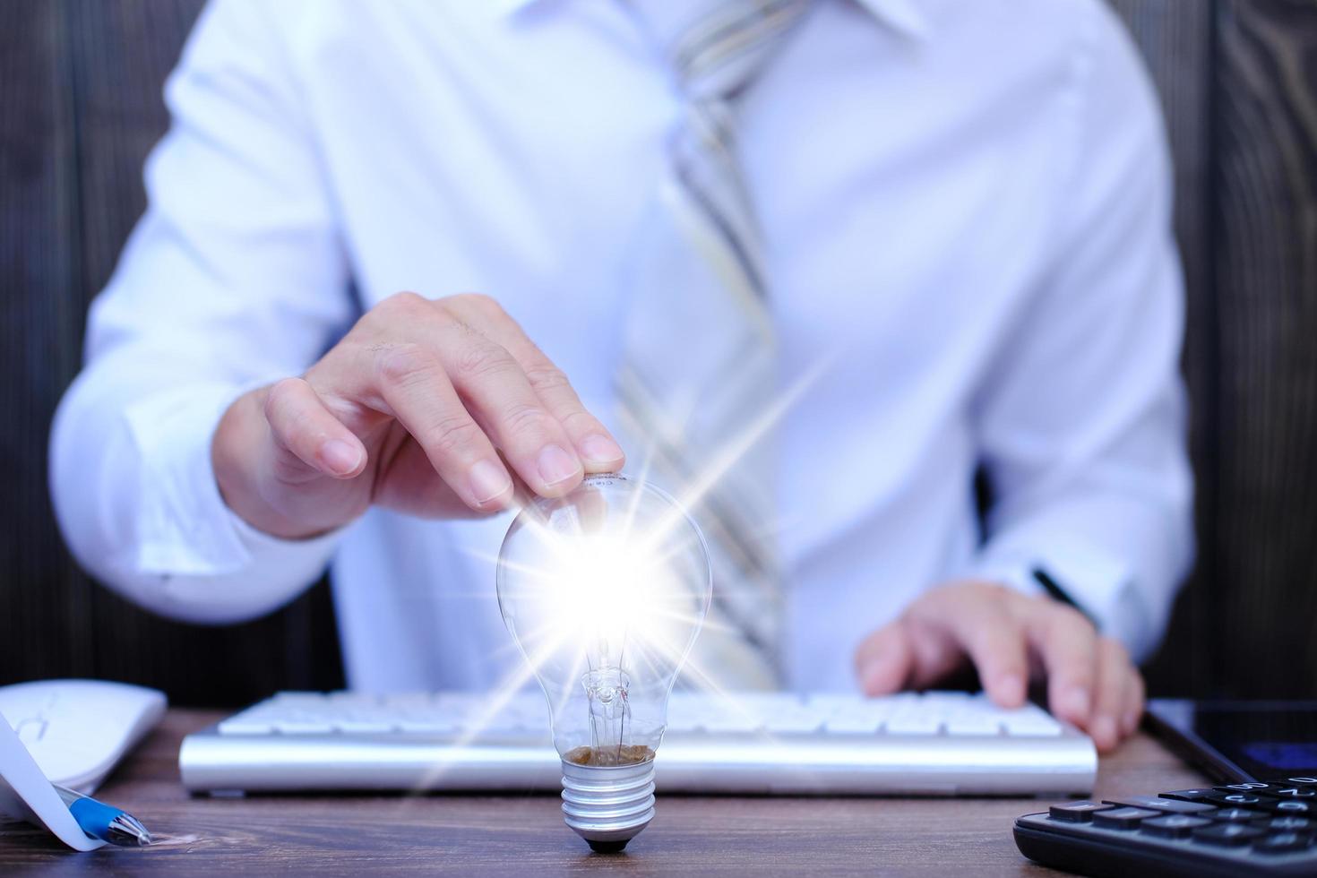 concept d'innovation et d'inspiration d'idée. homme d'affaires tenant une ampoule lumineuse, mains tenant une ampoule pour concept nouveau concept d'idée photo