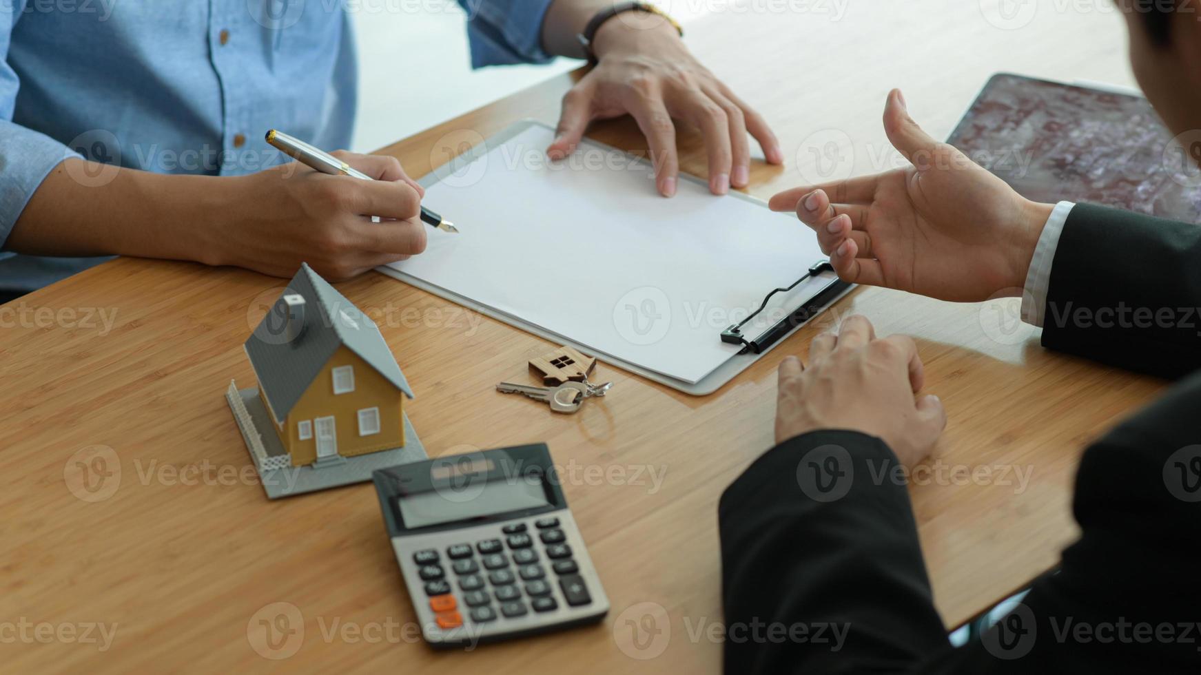 les agents d'assurance initient les clients à signer des contrats d'assurance immobilière. photo