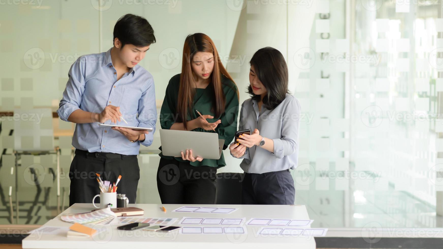 L'équipe commerciale a présenté les concepts avant la réunion avec les clients dans le bureau moderne équipé d'un ordinateur portable. photo