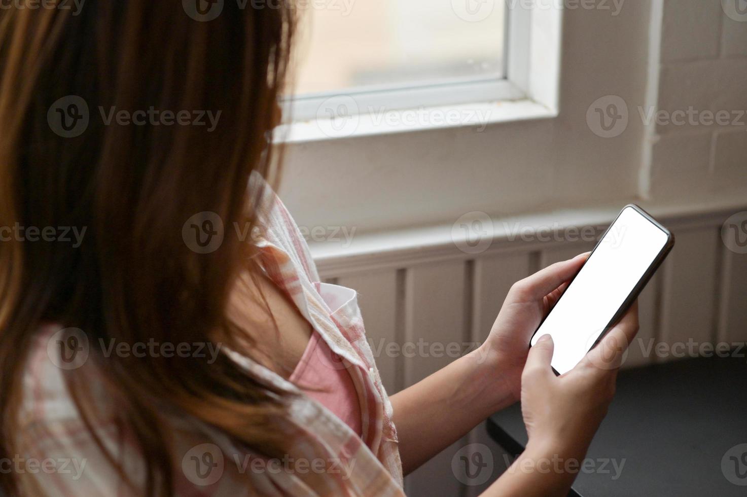gros plan d'une jeune femme utilisant un smartphone à la main pour rechercher des informations. photo