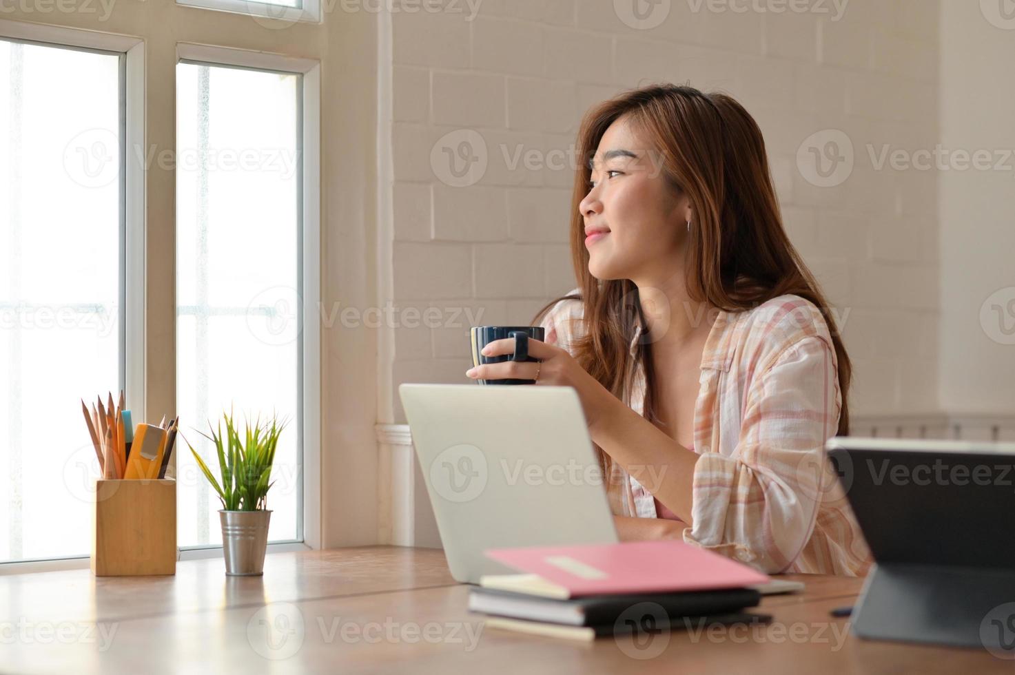 portrait d'un jeune étudiant buvant joyeusement du café en lisant pour la préparation à l'examen. photo