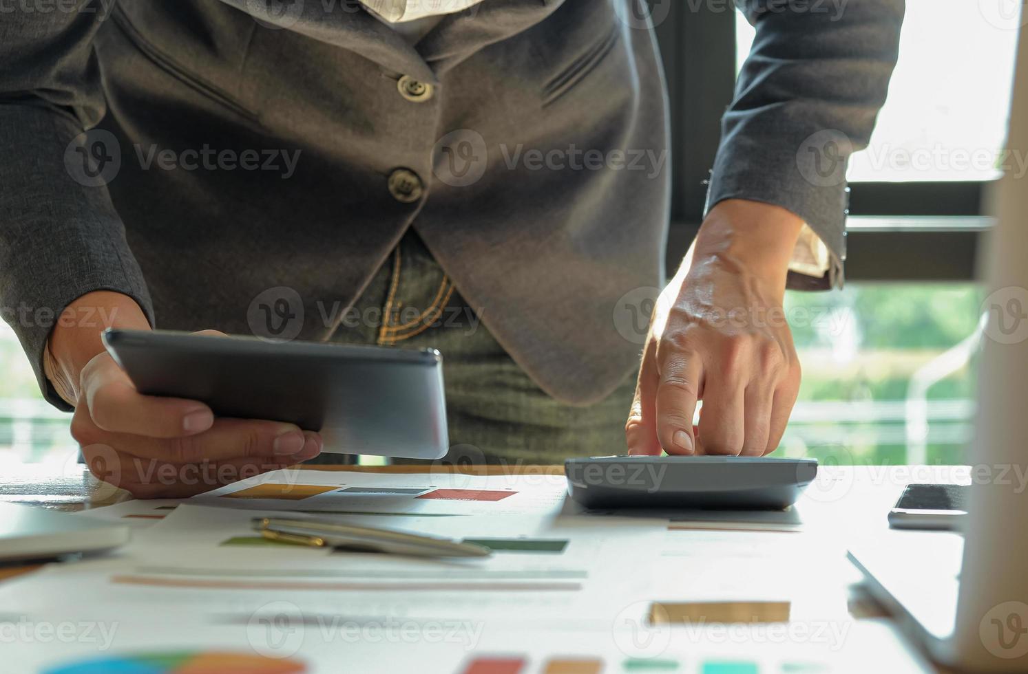 le concept d'un nouvel homme d'affaires utilise une tablette et des calculatrices au bureau. photo