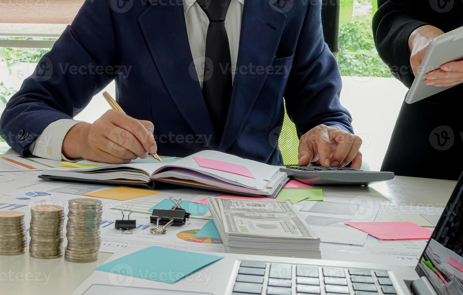 concept de finance d'entreprise, les hommes d'affaires utilisent une calculatrice et prennent des notes. photo