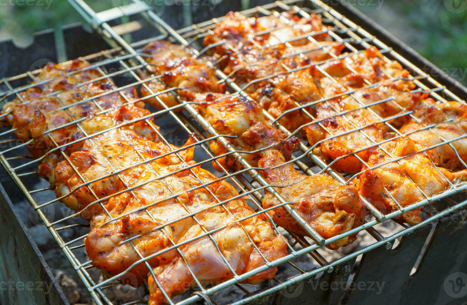 épicé mariné poulet ailes et jambes sur gril et sur une été barbecue. photo