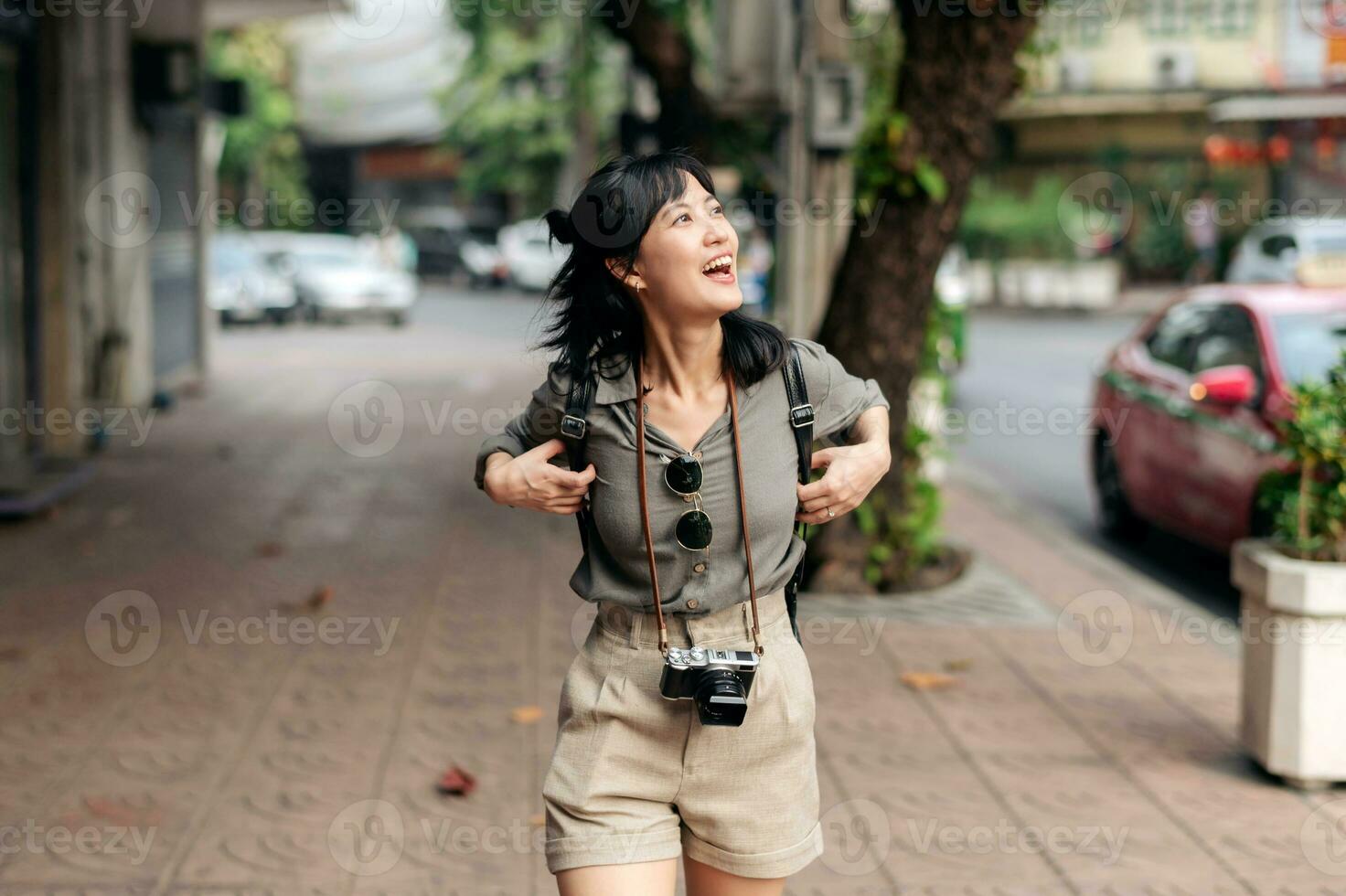 Jeune asiatique femme sac à dos voyageur profiter rue culturel local endroit et sourire. voyageur vérification en dehors côté des rues. photo