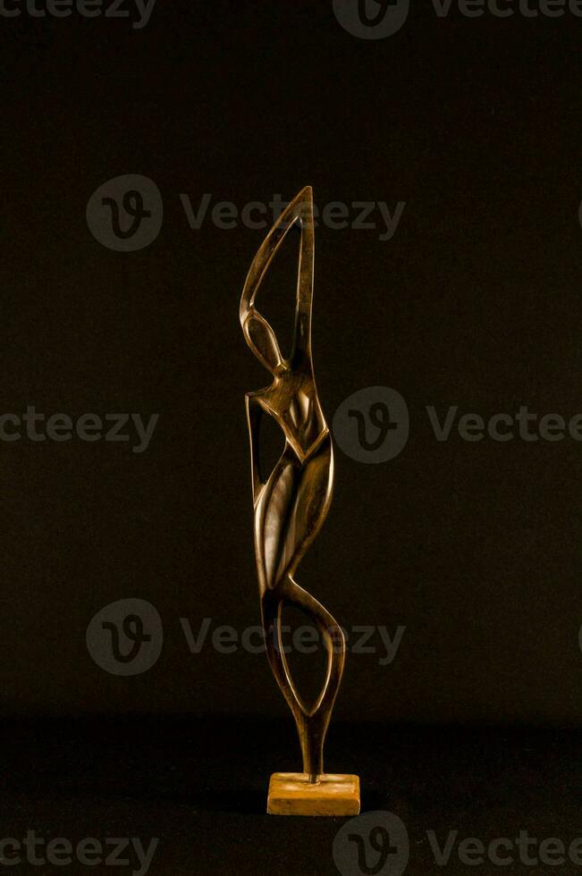 une bronze sculpture de une femme sur une en bois base photo