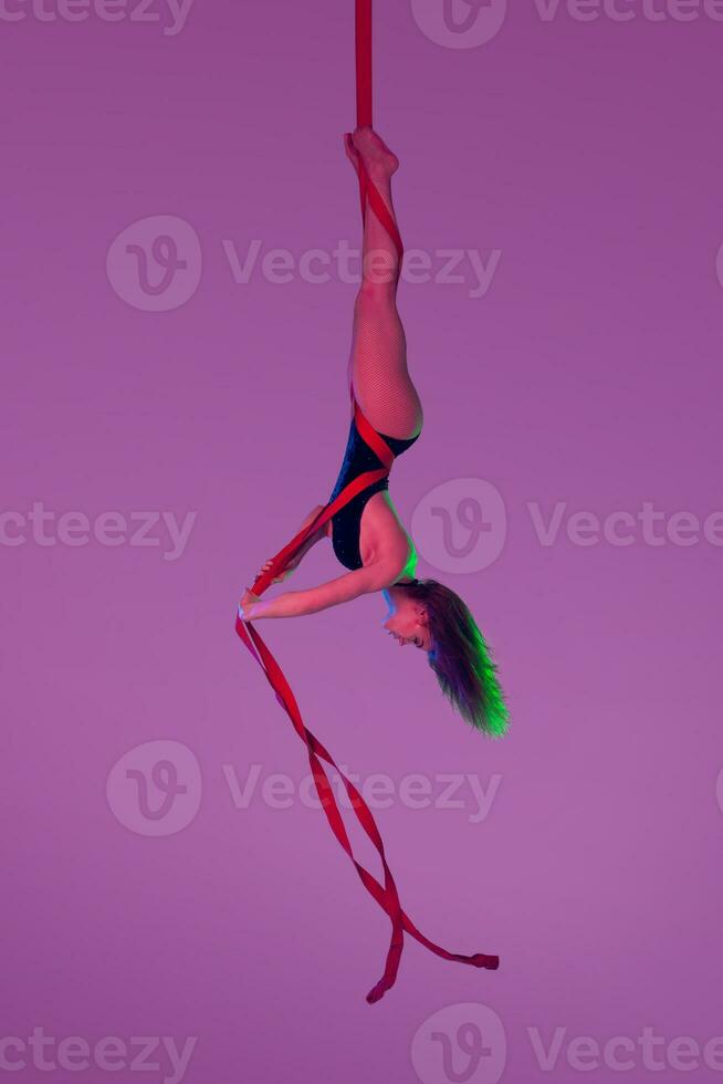 magnifique fille dans une noir maillot de bain est performant un acrobatique éléments dans studio. photo