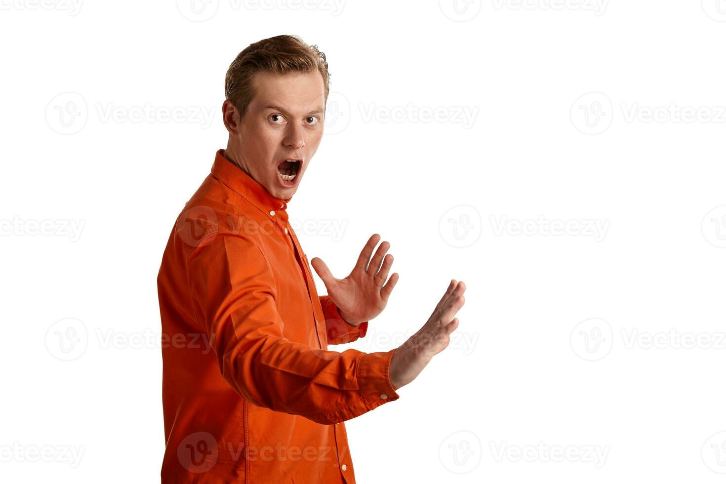 fermer portrait de une gingembre gars dans Orange chemise posant isolé sur blanc Contexte. sincère émotions. photo