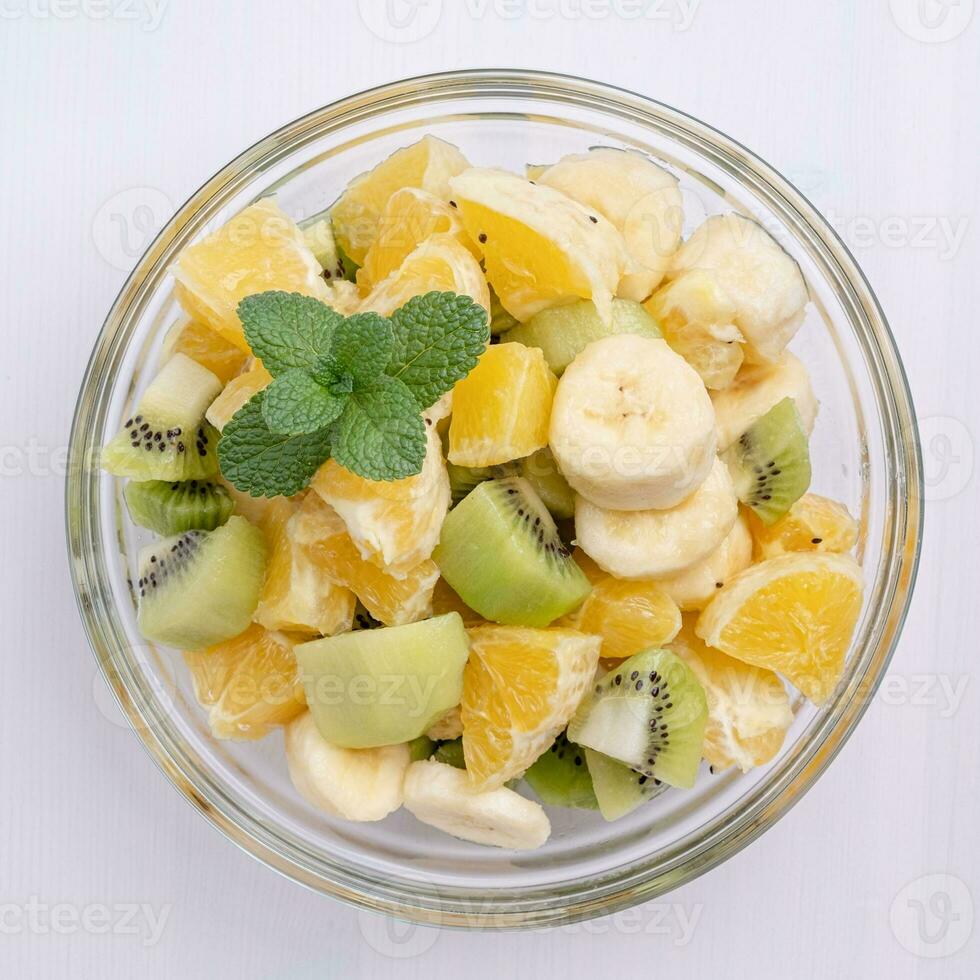bol de en bonne santé Frais fruit salade sur blanc Contexte photo