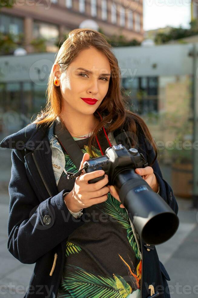 attrayant touristique femme photographe avec caméra, Extérieur dans ville rue. photo