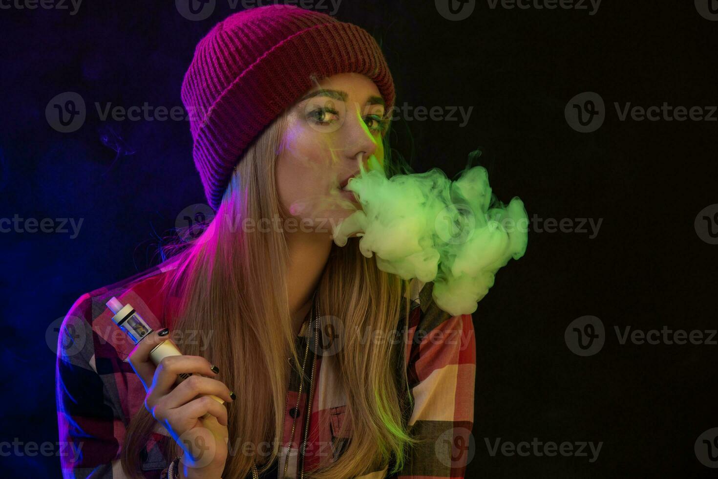 vapoter fille. Jeune branché femme vape e-cig sur studio sur noir Contexte. hip hop style. proche en haut. photo