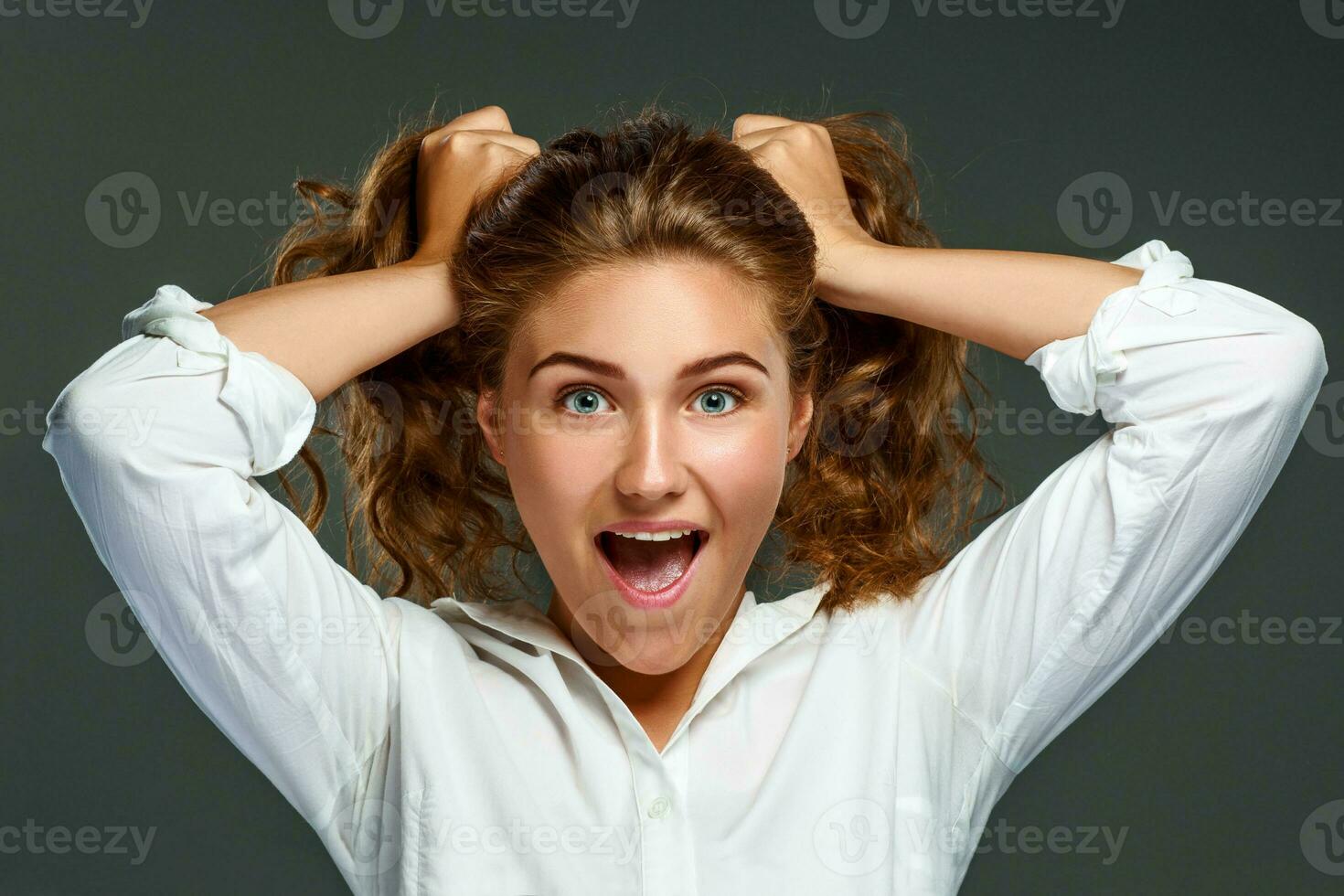 portrait espiègle Jeune brunette femme avec ondulé cheveux dans blanc photo