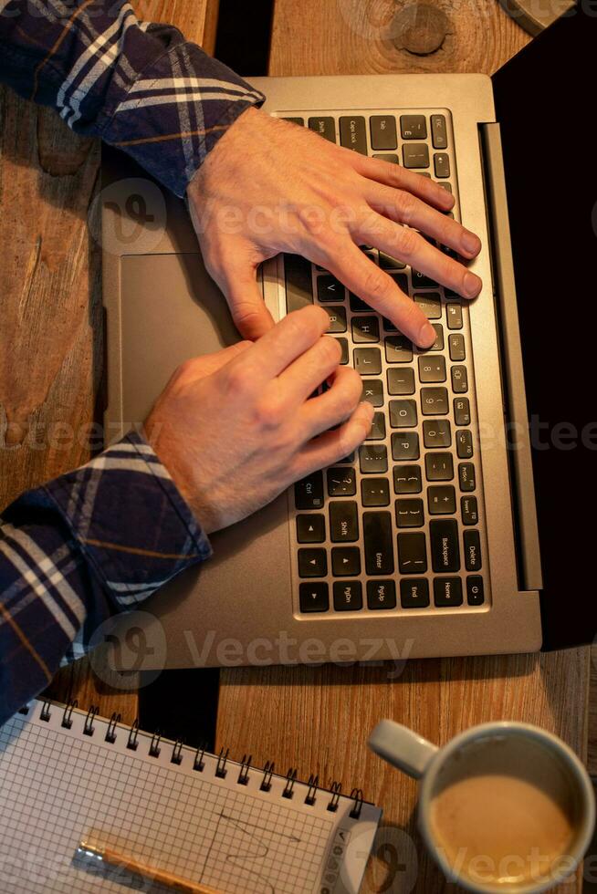 Jeune homme en buvant café dans café et en utilisant portable. homme mains en utilisant portable pendant café Pause photo