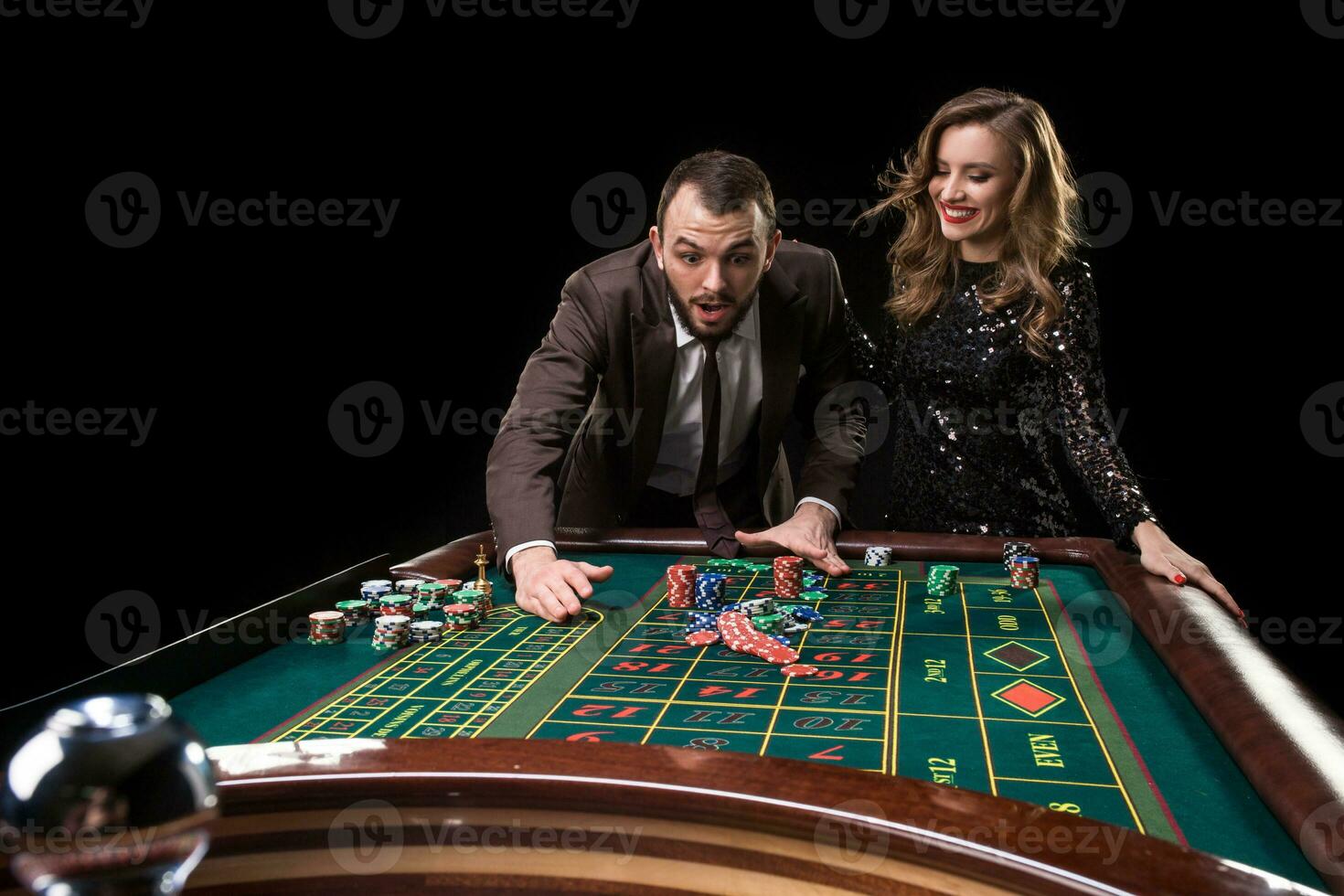 homme avec femme en jouant roulette à le casino. dépendance à le photo