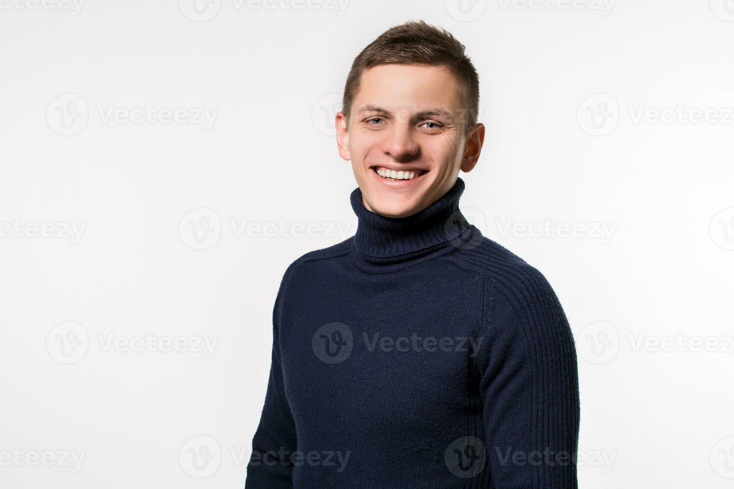 studio coup de Jeune homme portant bleu col roulé chandail contre photo