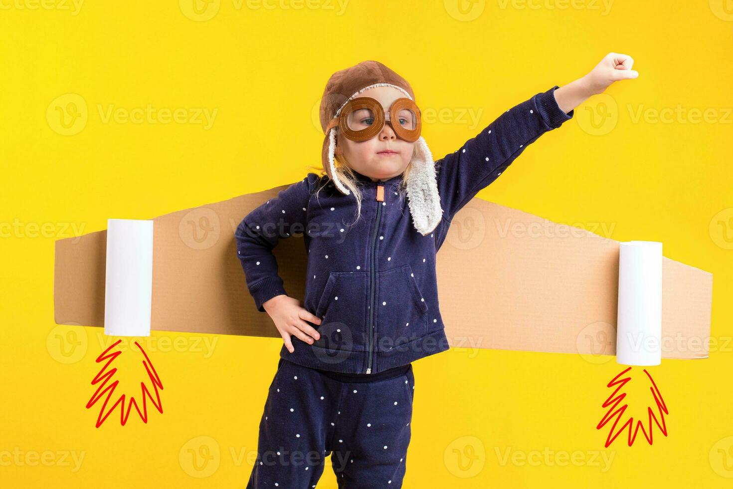 liberté, fille en jouant à être avion pilote, marrant peu fille avec aviateur casquette et lunettes, porte ailes fabriqué de marron papier carton comme un avion photo