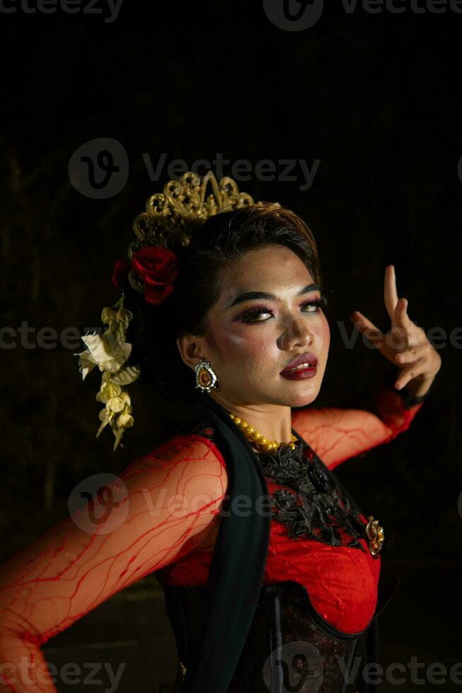 proche en haut de un indonésien femme dans une balinais Danseur costume posant très magnifiquement à nuit photo