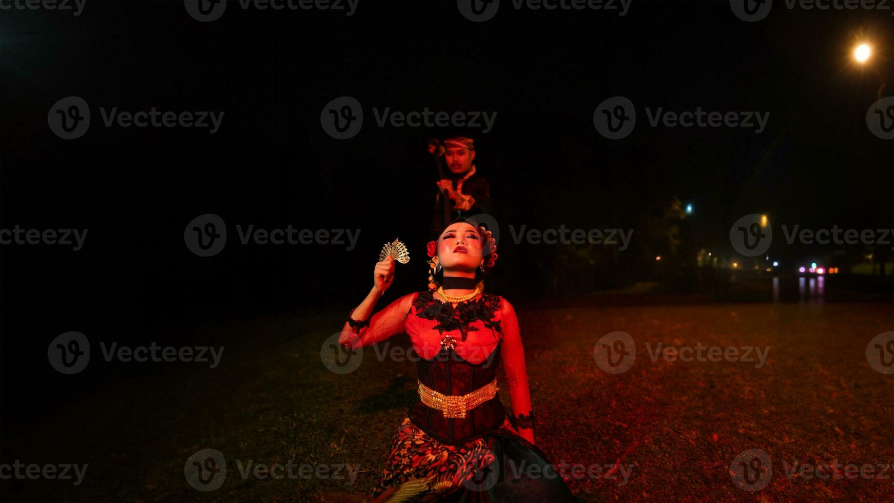 une femelle Danseur dans une rouge costume Sam dans le silence de le nuit lequel renforcé le tristesse photo