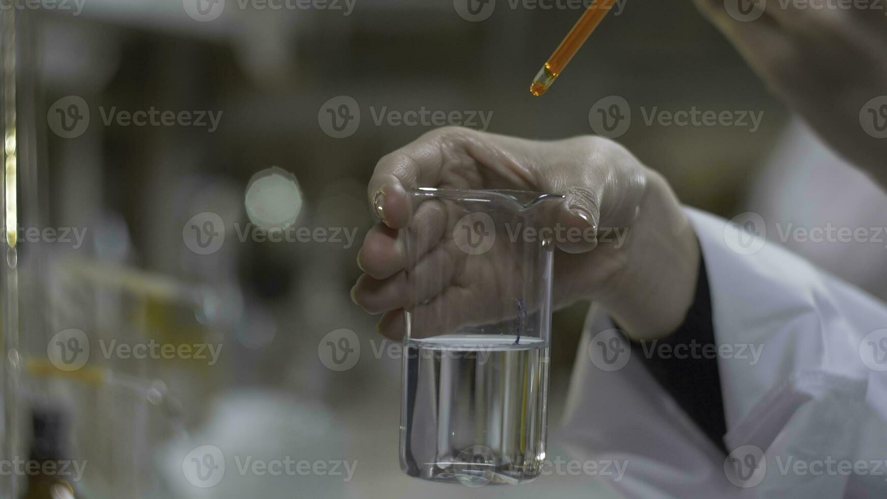 chimiste mains mixte substance de rouge Couleur dans tester tubes. médecin verse rouge produits chimiques dans dans ballon. proche en haut photo