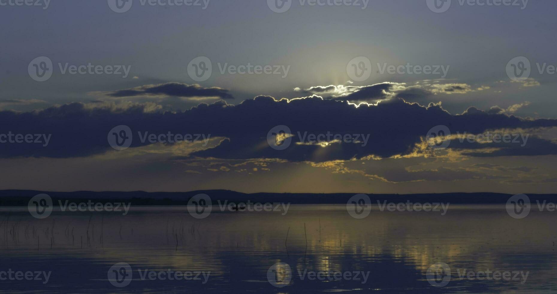 le coucher du soleil plus de lac. des nuages. l'eau. san dans le ciel. photo