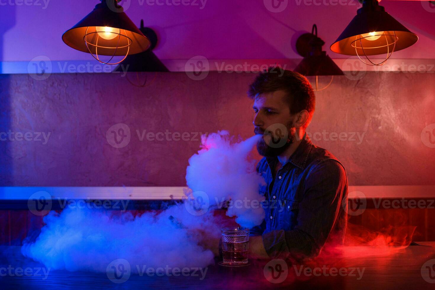 le homme fumée un électronique cigarette à le vape magasin. photo