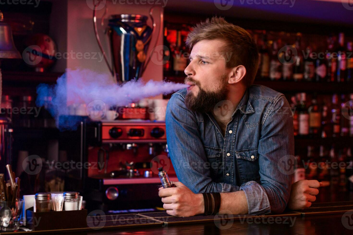 vapoter. vapoter homme dans une nuage de vapeur. photo est pris dans une vape bar.