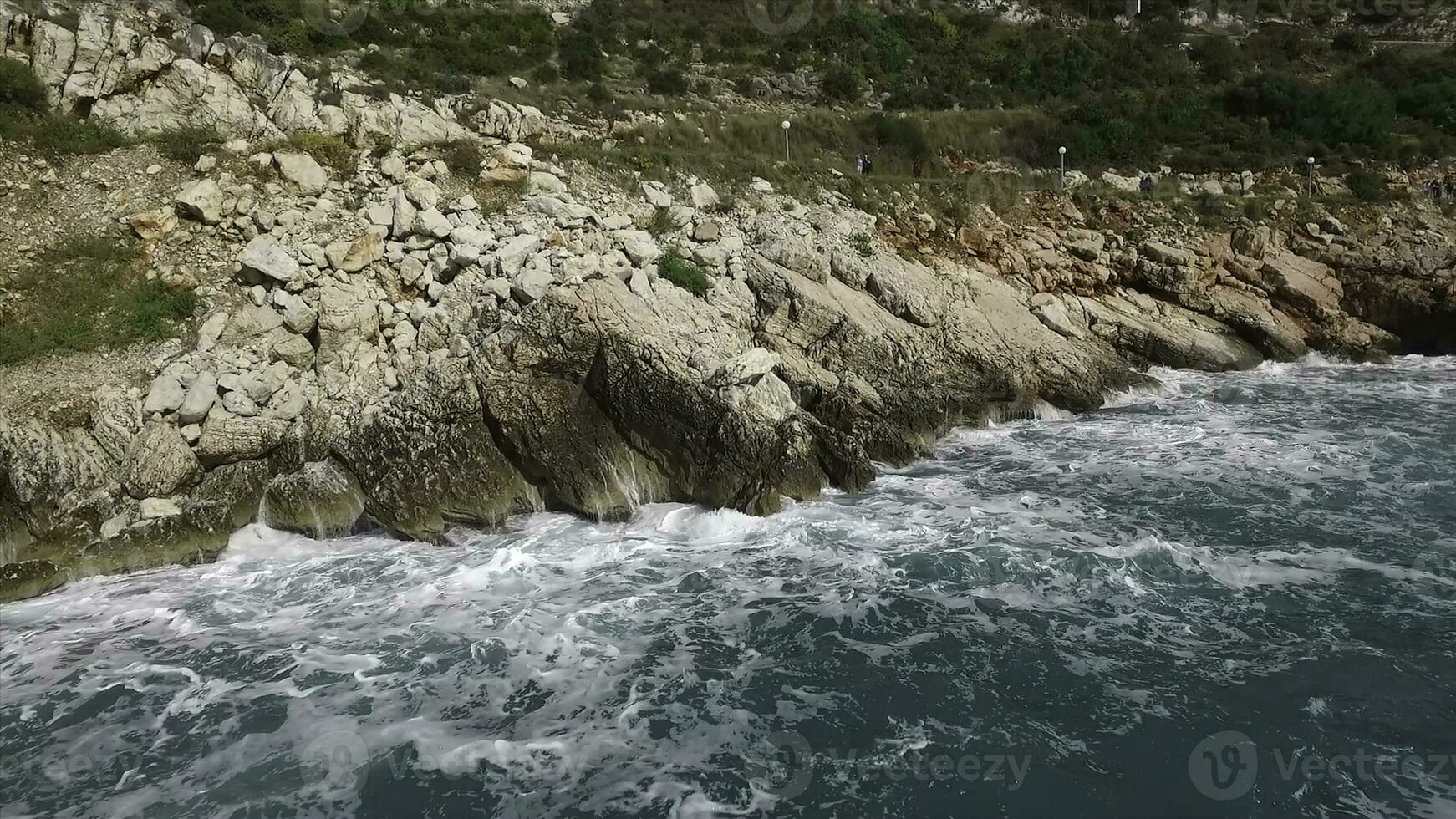 le vagues rupture sur une pierreux plage, formant une vaporisateur. images. éclabousser vagues sur le rochers de le mer photo