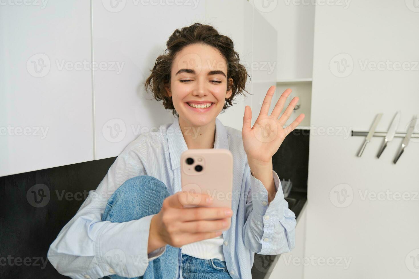 content souriant fille, en disant salut à une ami sur vidéo discuter, vagues à téléphone intelligent application, connecte à en ligne conversation sur sa téléphone photo