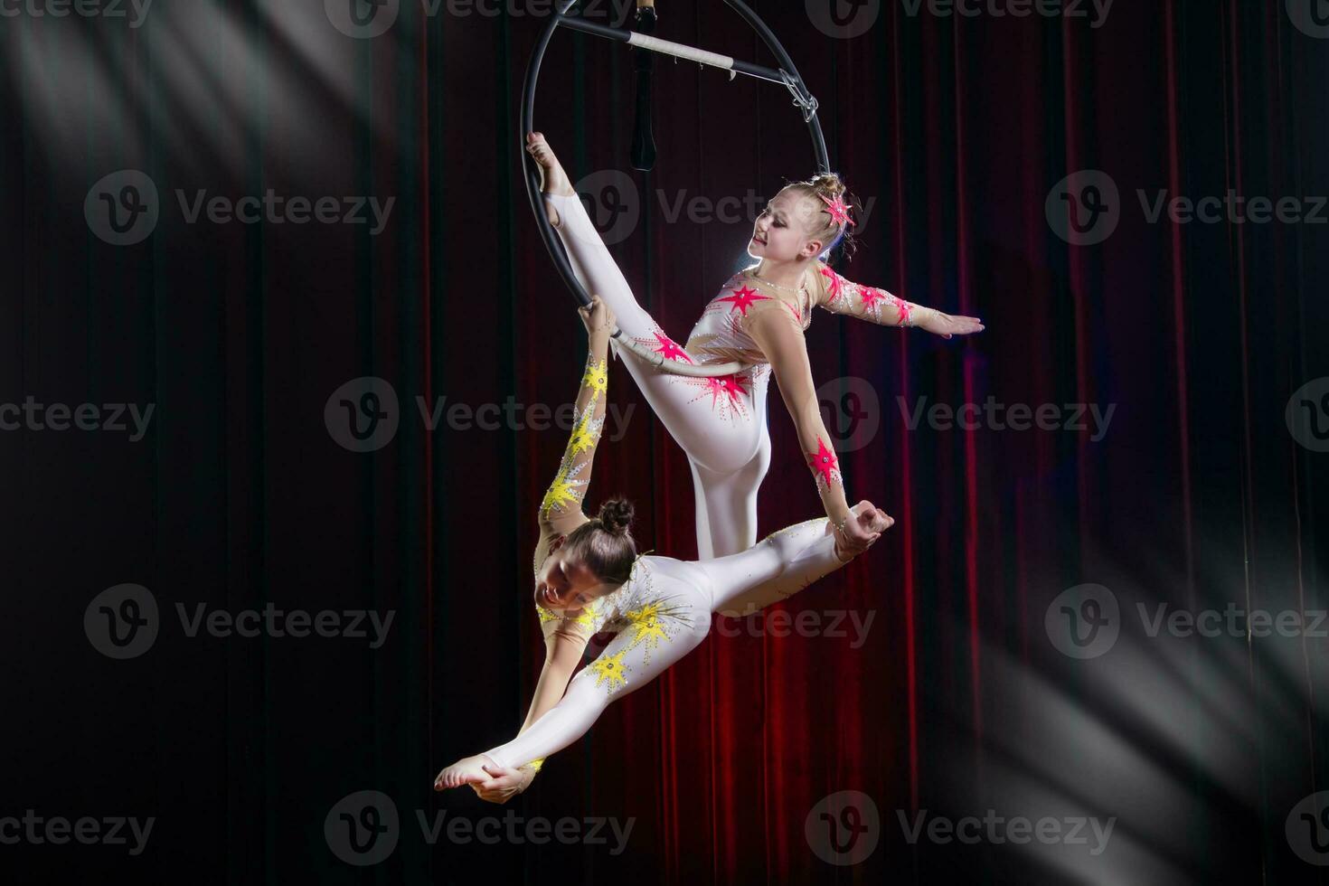 cirque actrice acrobate performance. deux les filles effectuer acrobatique éléments dans le air anneau. photo