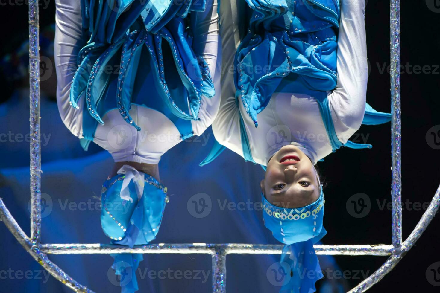 deux acrobate les filles spectacle une cirque nombre sur une foncé Contexte. acrobatique performance. photo