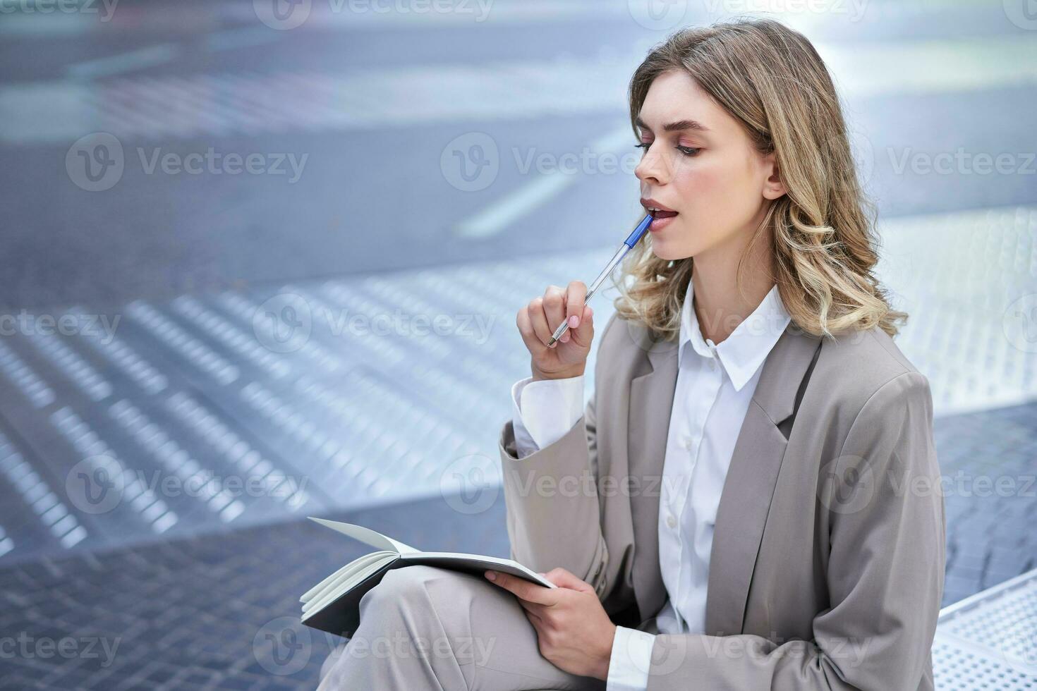 femme d'affaires séance dans ville centre avec carnet et stylo