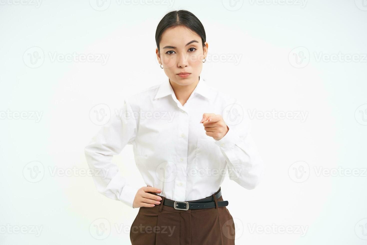 portrait de femme d'affaires avec strict, sérieux visage expression, points doigt à caméra, enseigne une leçon, blanc studio Contexte photo