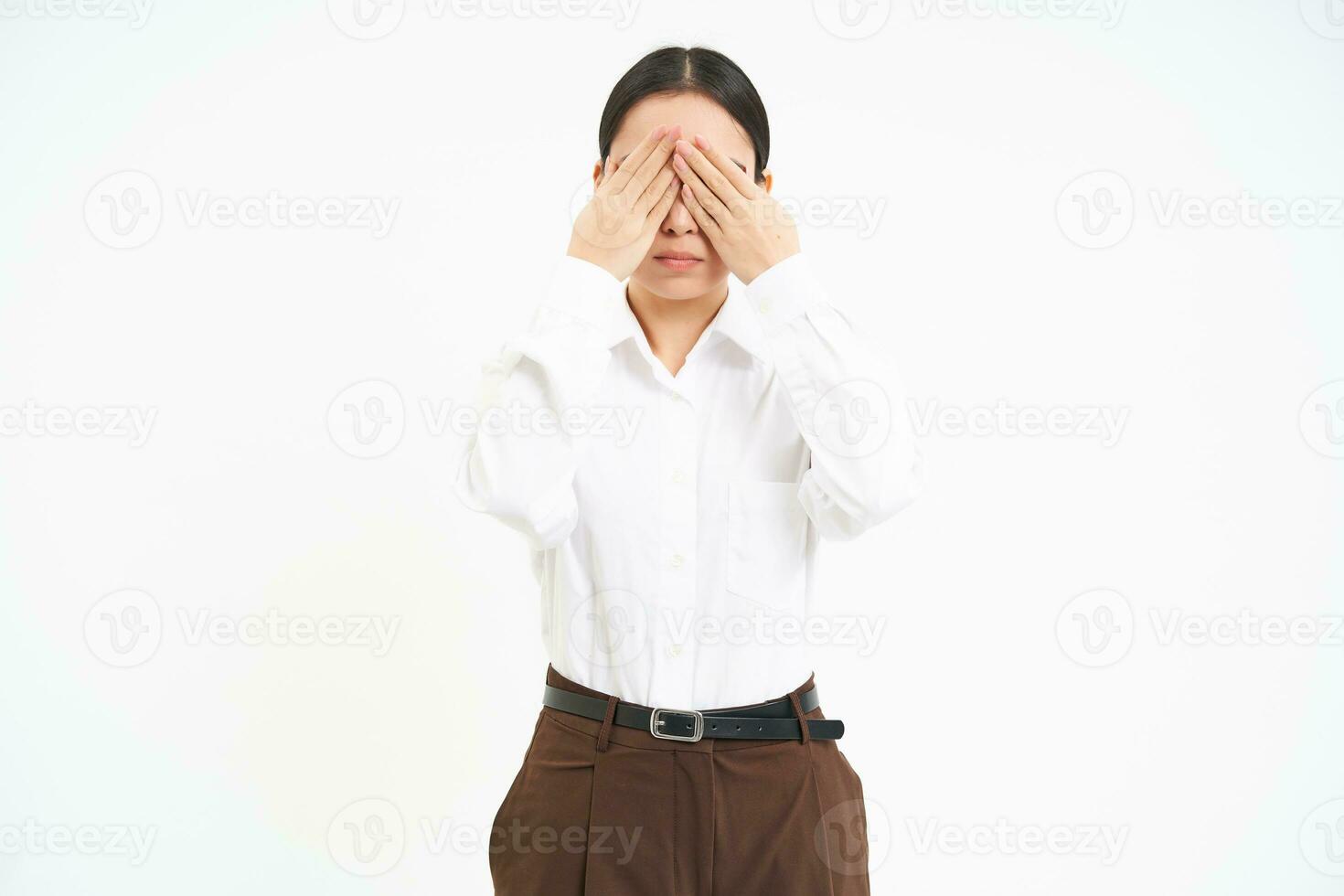 portrait de Jeune asiatique femme couvertures sa yeux avec mains, cache de quelque chose, blanc Contexte photo