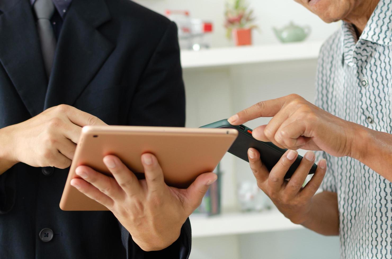 l'homme d'affaires utilise des téléphones portables et des tablettes pour la communication d'entreprise ou le marketing en ligne. photo