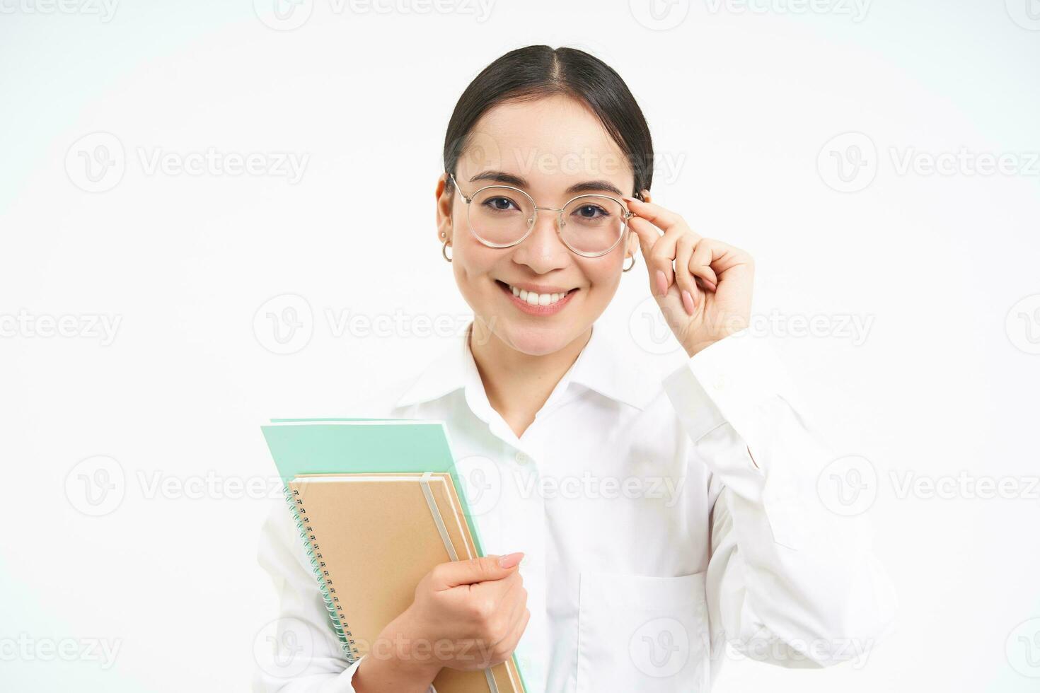 souriant femme professionnel, asiatique femelle prof avec lunettes, à la recherche confiant, permanent plus de blanc Contexte photo