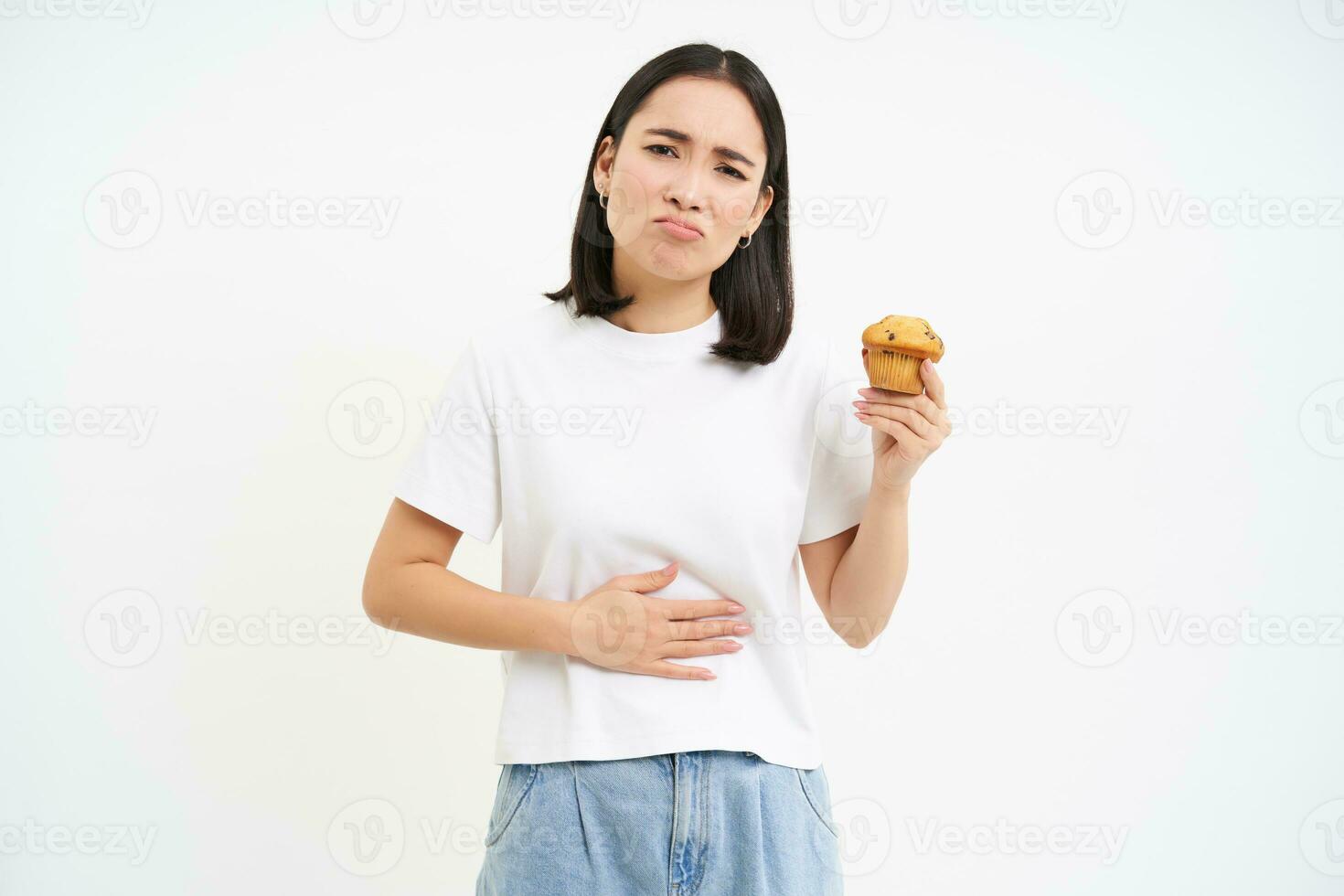portrait de asiatique femme avec estomac mal, en portant petit gâteau, nourriture empoisonnement, sentiment indisposé, studio Contexte photo