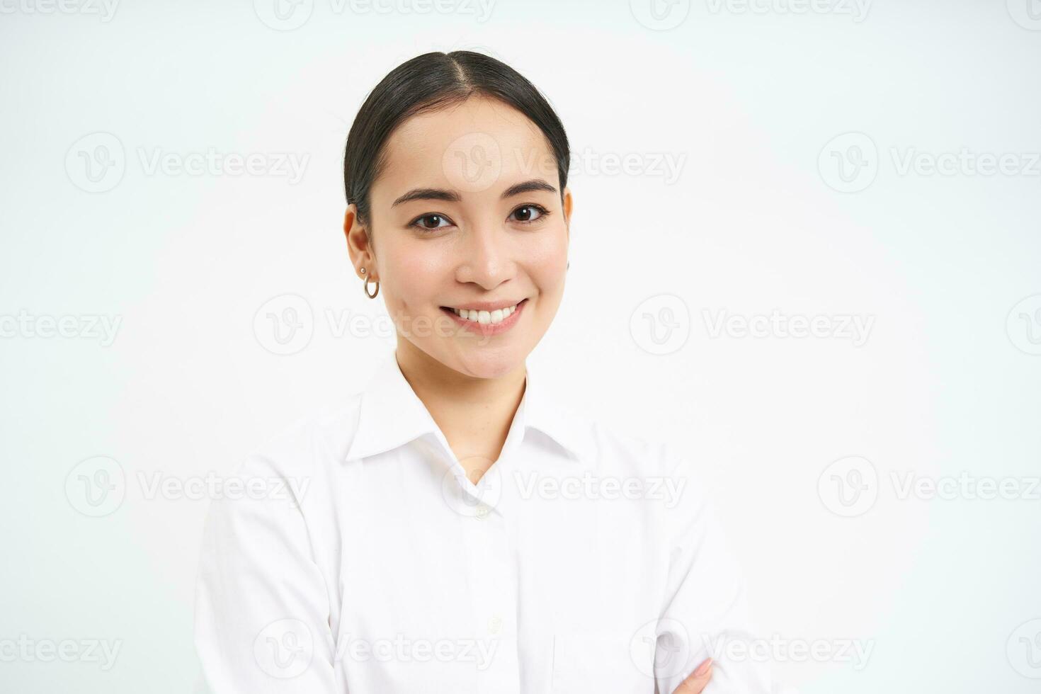 portrait de coréen femme d'affaires dans chemise, sourit à caméra, concept de entreprise gens et entreprise, des stands plus de blanc Contexte photo