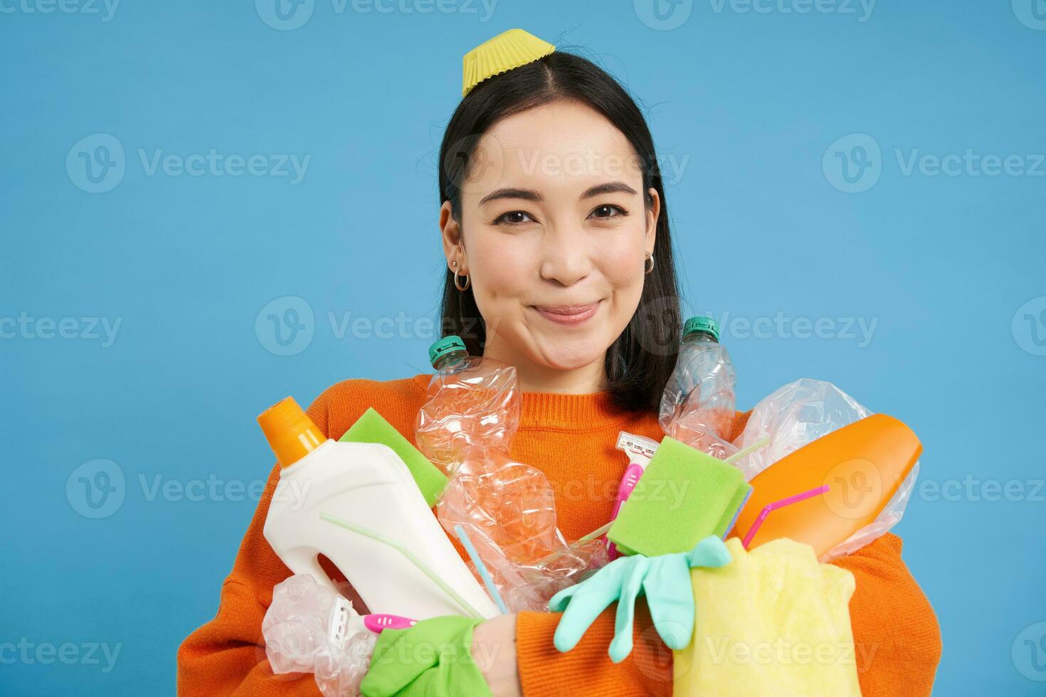 portrait de souriant asiatique femme avec Plastique ordures, en portant déchets et regards content, recueille litière pour recyclage centre, durable mode de vie concept photo