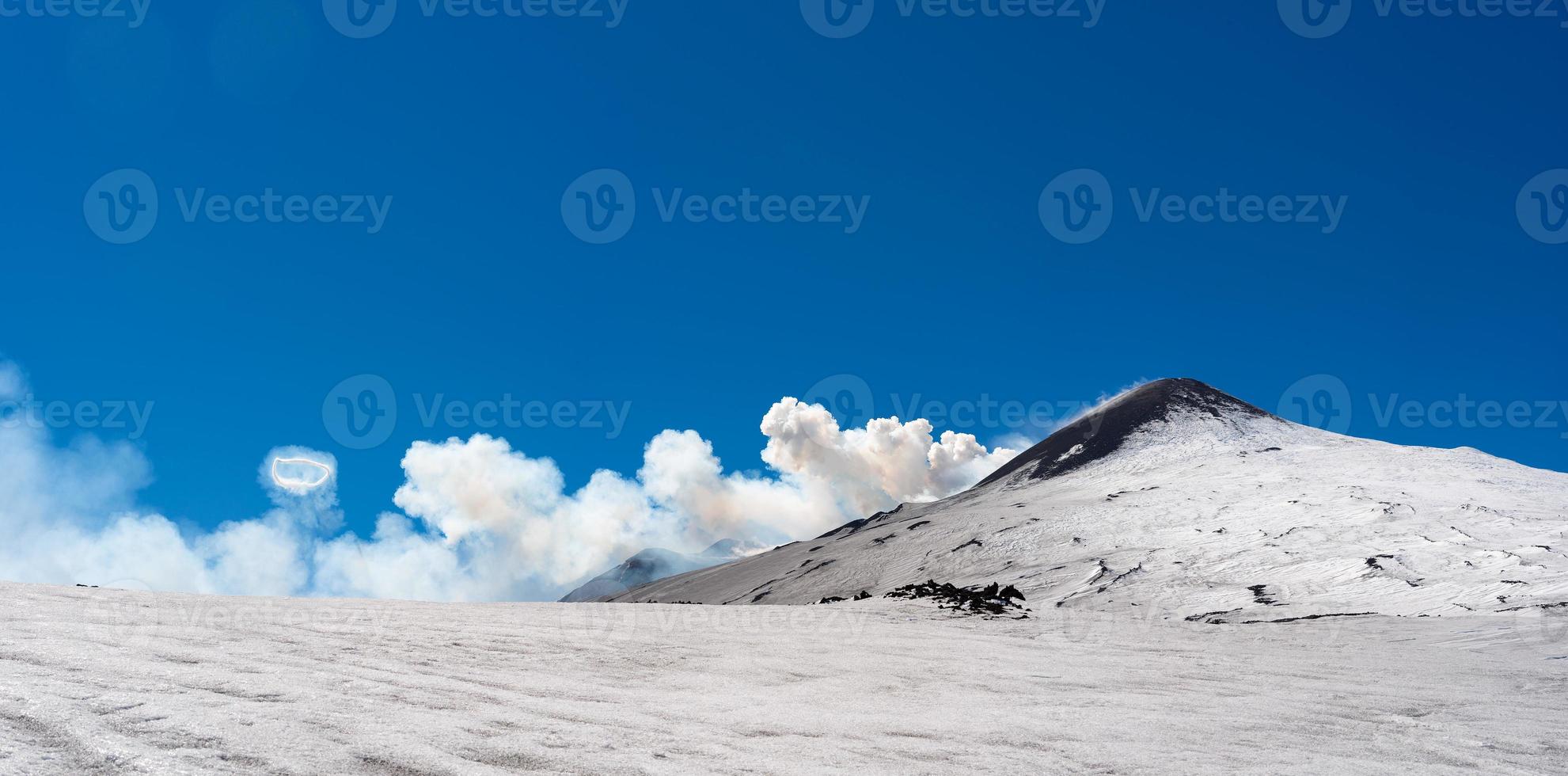 cratère sommital du volcan etna avec anneau de fumée phénomène spectaculaire d'aréole de vapeur pendant l'éruption photo