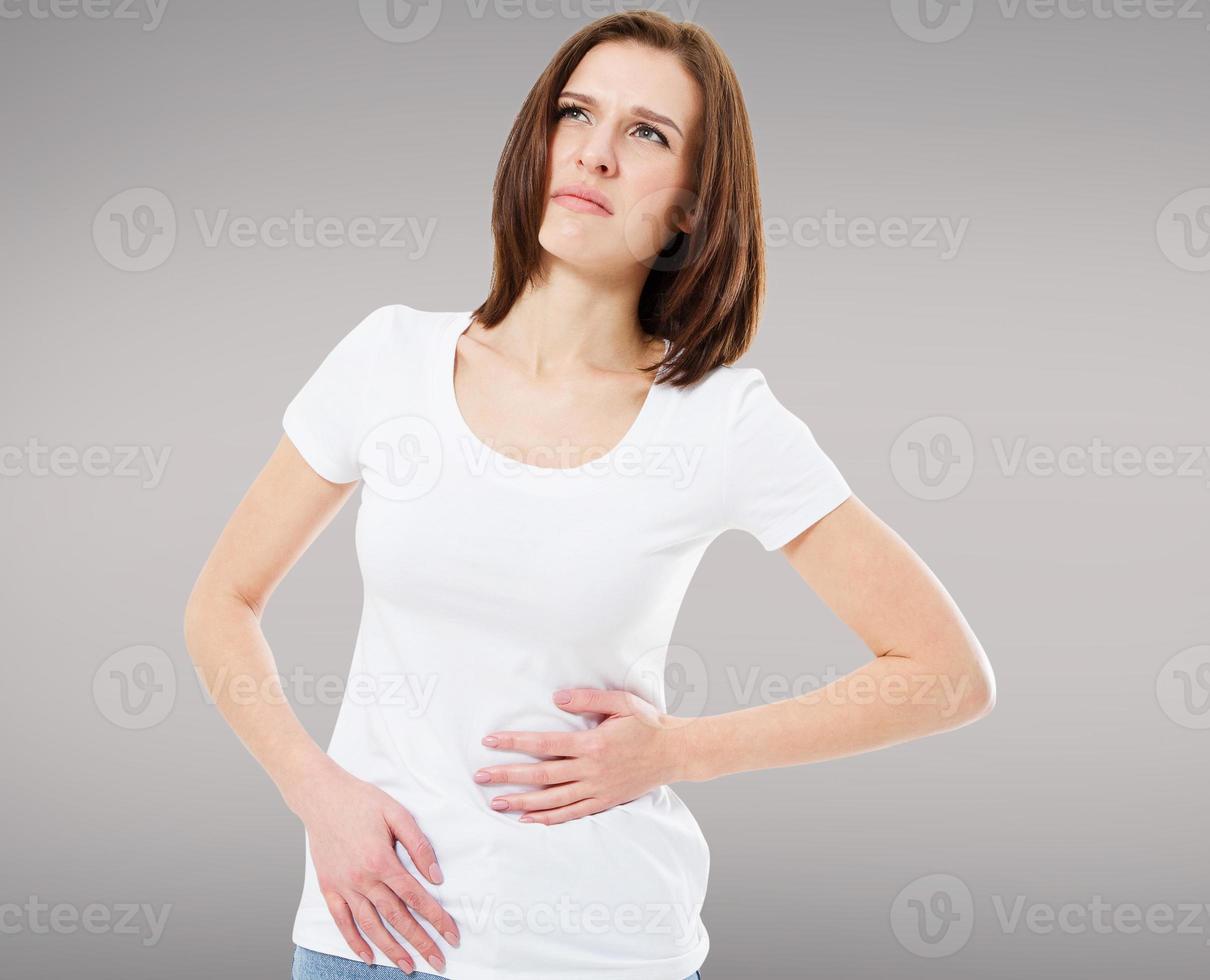 femme brune ayant des douleurs abdominales isolées sur gris photo