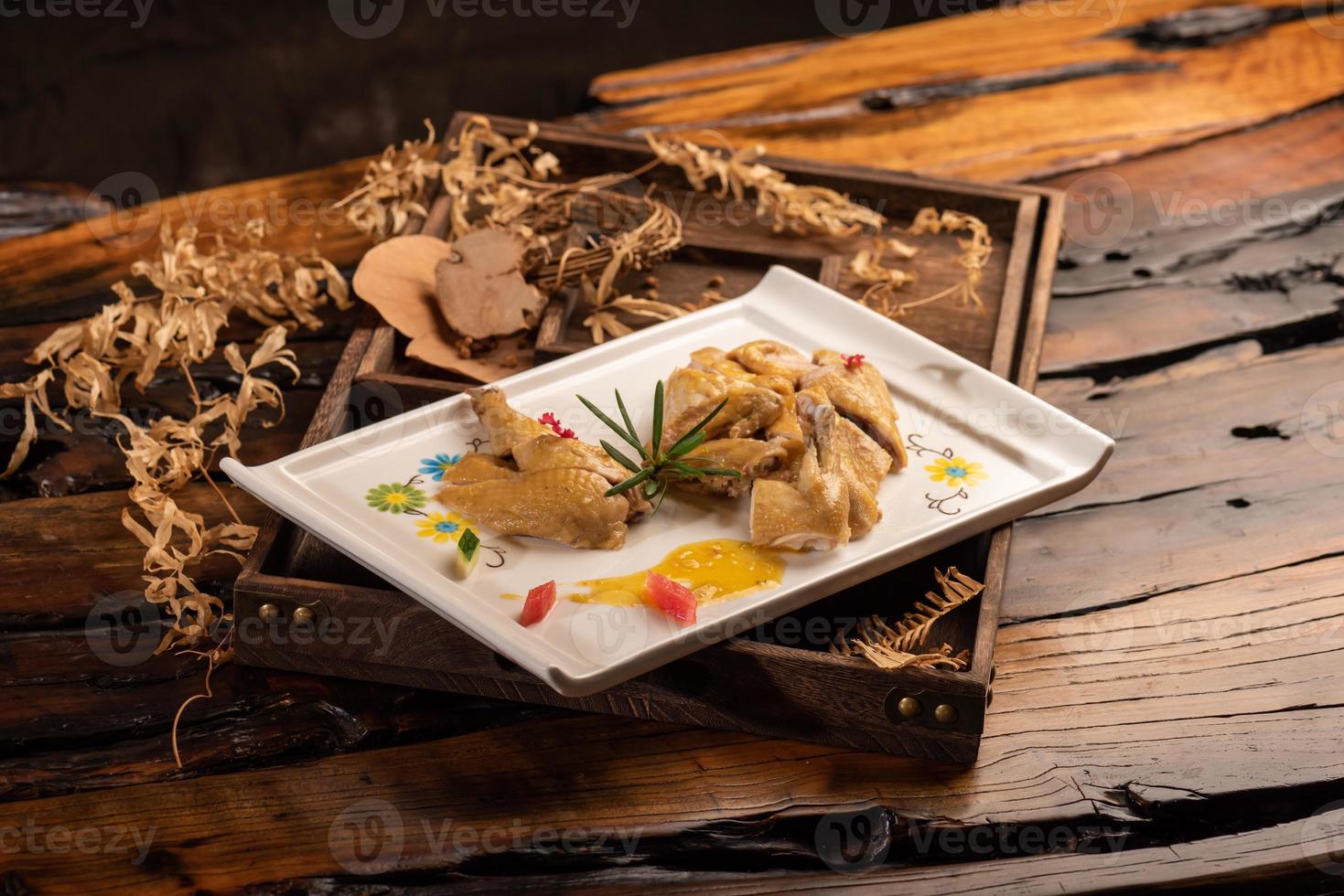 le canard jaune dans la longue assiette blanche est sur la table en bois photo