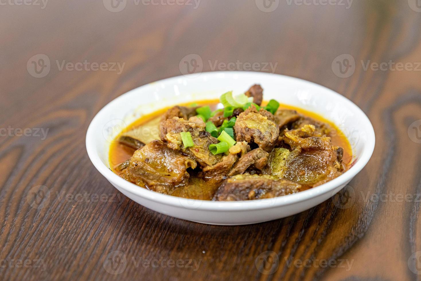 le plat de boeuf est dans l'assiette sur la table en bois photo