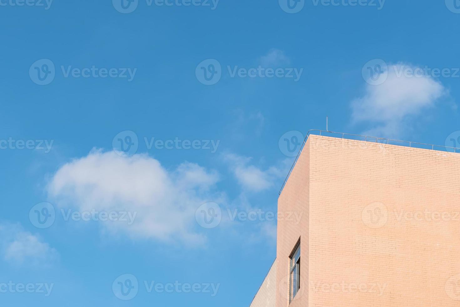 une partie du bâtiment jaune clair sous le ciel bleu et les nuages blancs photo